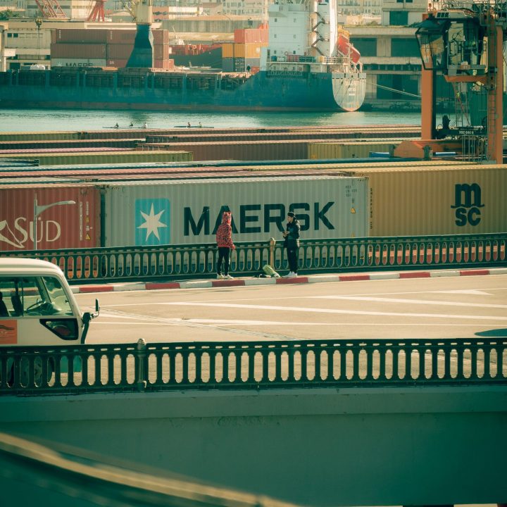 A vibrant harbor scene in Algiers with container ships and bustling activity, perfect for commercial use.